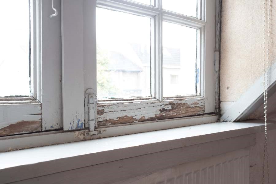 A window with peeling paint and a white sill located in Columbus, OH