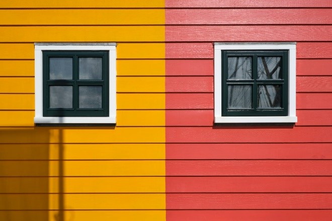A yellow and red wall with windows