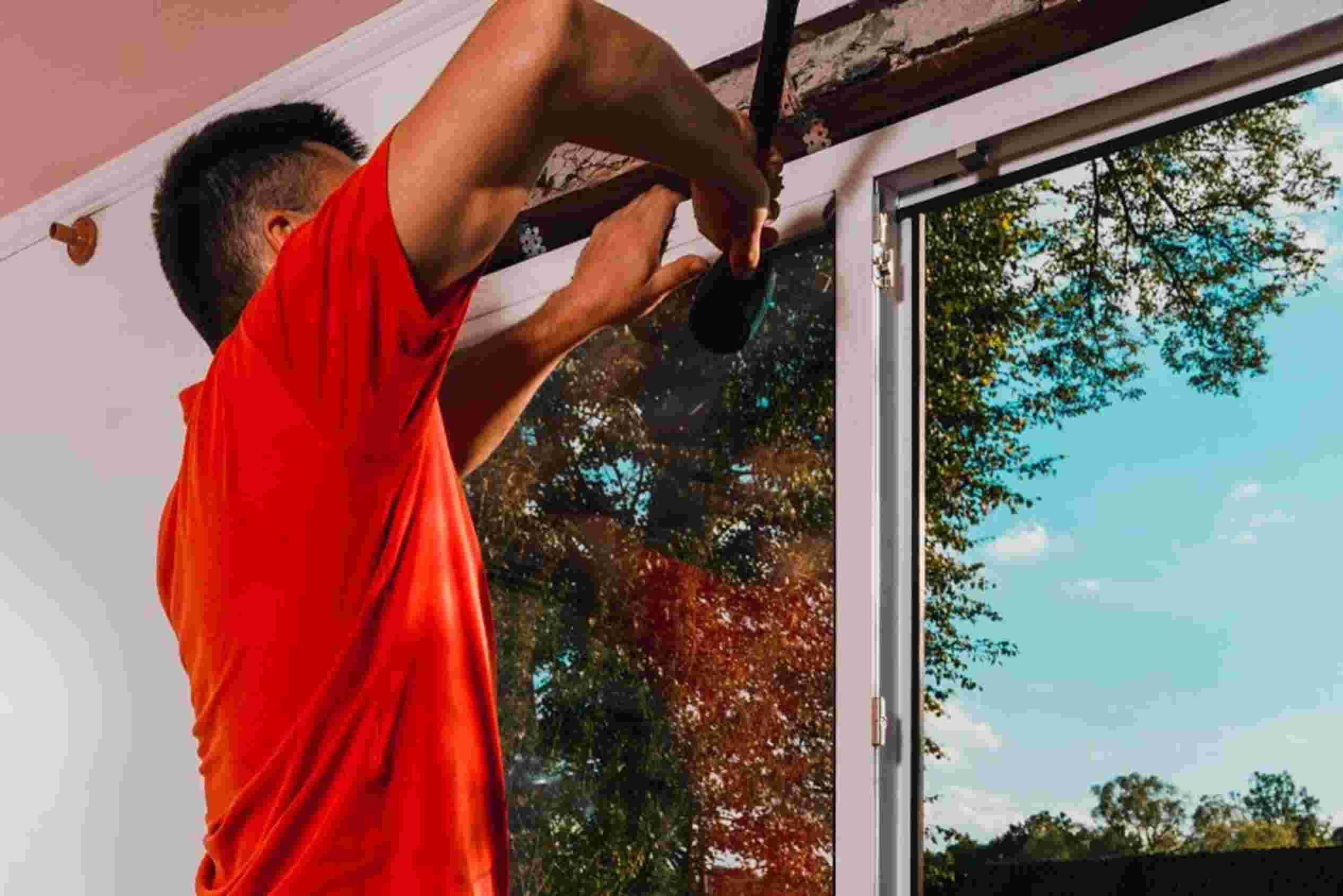A man is installing the new windows in the house with a hammer in Columbus, OH.